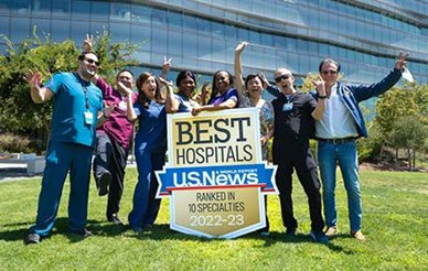 physicians standing in front of hospital holding us news world report ranking badge
