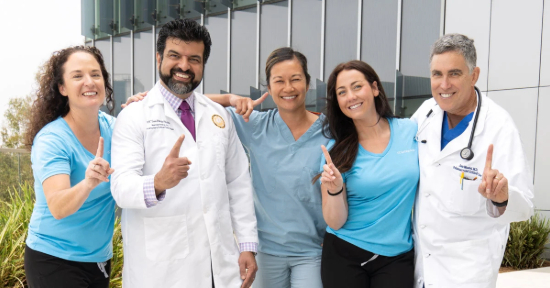 ucsd team standing outside hospital holding us news world report ranking sign