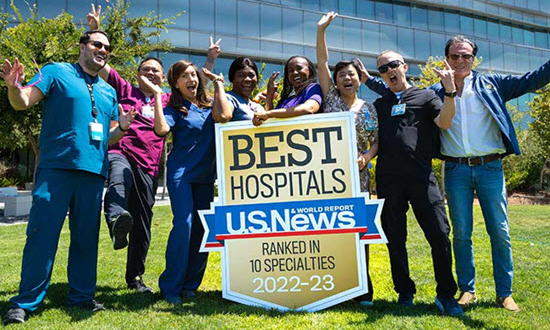 ucsd team standing outside hospital holding us news world report ranking sign